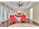 Spacious main bedroom featuring a decorative ceiling, ceiling fan, and two cozy armchairs at 1795 Anelli Ct, Henderson, NV 89012