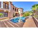 Luxury home showcasing a pool area featuring multiple palm trees, patios, and outdoor seating at 1795 Anelli Ct, Henderson, NV 89012