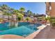 Beautiful pool area surrounded by lush greenery, palm trees, and lounge seating at 1795 Anelli Ct, Henderson, NV 89012