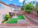 Mountain view backyard with artificial turf, stone pavers, patio cover, and desert landscaping at 189 Kings Canyon Court Ct, Henderson, NV 89012
