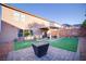 Fenced backyard featuring artificial grass, pavers, a covered patio, and fire pit at 189 Kings Canyon Court Ct, Henderson, NV 89012