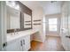 Bright bathroom with a double sink vanity, sleek fixtures, and decorative floating shelves at 189 Kings Canyon Court Ct, Henderson, NV 89012