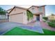 Attractive two-story home featuring an attached garage, desert landscaping, and lush, green turf at 189 Kings Canyon Court Ct, Henderson, NV 89012