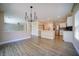 Open-concept living space boasts modern light fixture, neutral paint, and wood-look floors that seamlessly connect to kitchen at 189 Kings Canyon Court Ct, Henderson, NV 89012