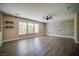 Spacious living room with wood-like flooring, a ceiling fan, and plenty of natural light at 189 Kings Canyon Court Ct, Henderson, NV 89012
