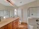 Bathroom featuring a dual sink vanity, glass-enclosed shower and tub combination at 209 Tainted Berry Ave, North Las Vegas, NV 89031