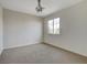 An airy bedroom offers neutral walls, plush carpet, a chandelier, and natural light from the window at 209 Tainted Berry Ave, North Las Vegas, NV 89031