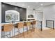 Stylish bar area with modern stools, marble countertop, gray tiled backsplash, and a window with shutters at 211 Granite Ct, Boulder City, NV 89005