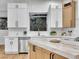 Modern kitchen features white and wood cabinets, marble countertops, stainless steel appliances, and a unique window view at 211 Granite Ct, Boulder City, NV 89005