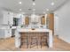 Bright, modern kitchen with white cabinets, a marble island with seating, and stainless steel appliances at 211 Granite Ct, Boulder City, NV 89005