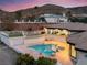 A beautiful backyard pool and spa at twilight, with mountain views in the distance at 211 Granite Ct, Boulder City, NV 89005