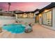Backyard featuring pool, rock details, covered patio, and large windows in the main house at 211 Granite Ct, Boulder City, NV 89005