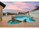 A beautiful pool and spa combination is surrounded by stone accents and lush landscaping at 211 Granite Ct, Boulder City, NV 89005