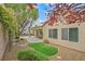 Inviting backyard showcases lush desert landscaping, mature trees, and a relaxing covered patio area at 2429 Wisconsin Dells Dr, Henderson, NV 89044