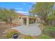 Charming backyard with mature trees, a stone border, and covered patio area with furniture at 2429 Wisconsin Dells Dr, Henderson, NV 89044