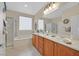 Bright bathroom featuring a double vanity, soaking tub, and separate glass-enclosed shower at 2429 Wisconsin Dells Dr, Henderson, NV 89044