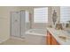 Well-lit bathroom showcasing a soaking tub, glass-enclosed shower, and vanity with sink at 2429 Wisconsin Dells Dr, Henderson, NV 89044