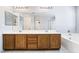 Bathroom features double sink vanity with tile flooring, large mirrors, and wood cabinets at 2482 Denholme St, Henderson, NV 89044
