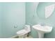 This half bathroom features a pedestal sink, and a coordinating round mirror at 2482 Denholme St, Henderson, NV 89044