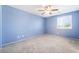 Bedroom featuring neutral carpet, shutters on the window, and blue painted walls at 2482 Denholme St, Henderson, NV 89044