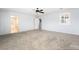 Oversized primary bedroom featuring neutral carpeting, a ceiling fan, and ensuite bathroom at 2482 Denholme St, Henderson, NV 89044