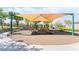 Community playground under a shade structure with multiple play features, offering a safe and enjoyable space for children at 2482 Denholme St, Henderson, NV 89044