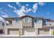 Modern townhouse exterior with three garage doors and neutral color palette under blue sky at 25 Barbara Ln # 57, Las Vegas, NV 89183