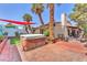 Private backyard featuring a hot tub, mature palm trees, and brick-paved patio at 2583 Egret Cir, Las Vegas, NV 89121