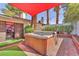 Backyard hot tub area with turf and access to house; partially shaded by a red sail at 2583 Egret Cir, Las Vegas, NV 89121