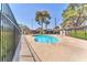 Community pool offering a serene environment with mature trees, a sunbathing area, and gated access for resident enjoyment at 2583 Egret Cir, Las Vegas, NV 89121