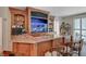 Custom bar area featuring granite countertops, wooden cabinetry, bar seating, and a built-in aquarium at 2747 Paradise Rd # 501, Las Vegas, NV 89109