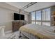 Comfortable bedroom with a four-poster bed, a wooden dresser with a television, and large windows with great outdoor views at 2747 Paradise Rd # 501, Las Vegas, NV 89109
