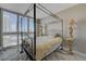 Bright bedroom featuring a four-poster bed, elegant bedside lamps, and large windows with stunning city views at 2747 Paradise Rd # 501, Las Vegas, NV 89109