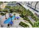 Aerial view of luxurious pool with lounge area, mature landscaping and tennis courts at 2747 Paradise Rd # 501, Las Vegas, NV 89109
