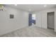 A modern bedroom features gray wood floors, a blue door to a partial view of a kitchenette, and a mirrored closet at 2839 Boise St, Las Vegas, NV 89121