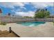 An in-ground pool is surrounded by a gray block wall and a concrete patio, beneath a cloudy sky at 2839 Boise St, Las Vegas, NV 89121