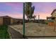 Backyard with a shed, mature tree, hardscape and spa under a colorful dusk sky at 3193 Emerald Creek Dr, Las Vegas, NV 89156