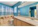 A bright bathroom featuring a beach themed shower curtain, bright light and vanity at 3193 Emerald Creek Dr, Las Vegas, NV 89156