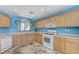 Well-lit kitchen with modern white appliances, hanging plants, and plenty of cabinet space at 3193 Emerald Creek Dr, Las Vegas, NV 89156