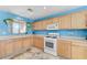 Spacious kitchen with white modern appliances, hanging plants, and plenty of cabinet space at 3193 Emerald Creek Dr, Las Vegas, NV 89156