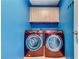 A well-equipped laundry room with modern red washer and dryer units and upper cabinets at 3193 Emerald Creek Dr, Las Vegas, NV 89156