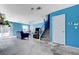 Spacious living room with bright blue walls, ceiling fan, and stairs leading upstairs at 3193 Emerald Creek Dr, Las Vegas, NV 89156