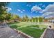 Expansive backyard featuring lush lawn, putting green, and mature trees at 3518 W Agate Ave, Las Vegas, NV 89139