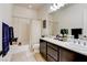 Bright bathroom featuring dual sink vanity with neutral countertops and cabinets, a shower-tub combination, and large mirror at 3518 W Agate Ave, Las Vegas, NV 89139