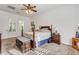 Comfortable bedroom features a ceiling fan, carpet, shutters and a king-sized bed with matching bedside tables at 3518 W Agate Ave, Las Vegas, NV 89139