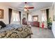 Brightly lit bedroom with a ceiling fan, dresser, and large windows with curtains at 3518 W Agate Ave, Las Vegas, NV 89139