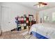 This bedroom offers carpeted floors, shutters, ceiling fan and is furnished with a king-sized bed and a colorful storage unit at 3518 W Agate Ave, Las Vegas, NV 89139