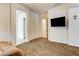 Spacious bedroom area with carpet and a wall-mounted TV, creating a relaxing space at 3518 W Agate Ave, Las Vegas, NV 89139