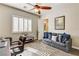 Inviting bedroom features plantation shutters, ceiling fan, and a comfortable seating area at 3518 W Agate Ave, Las Vegas, NV 89139