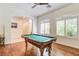 Open game room boasts a billiard table and hardwood flooring with backyard views at 3518 W Agate Ave, Las Vegas, NV 89139